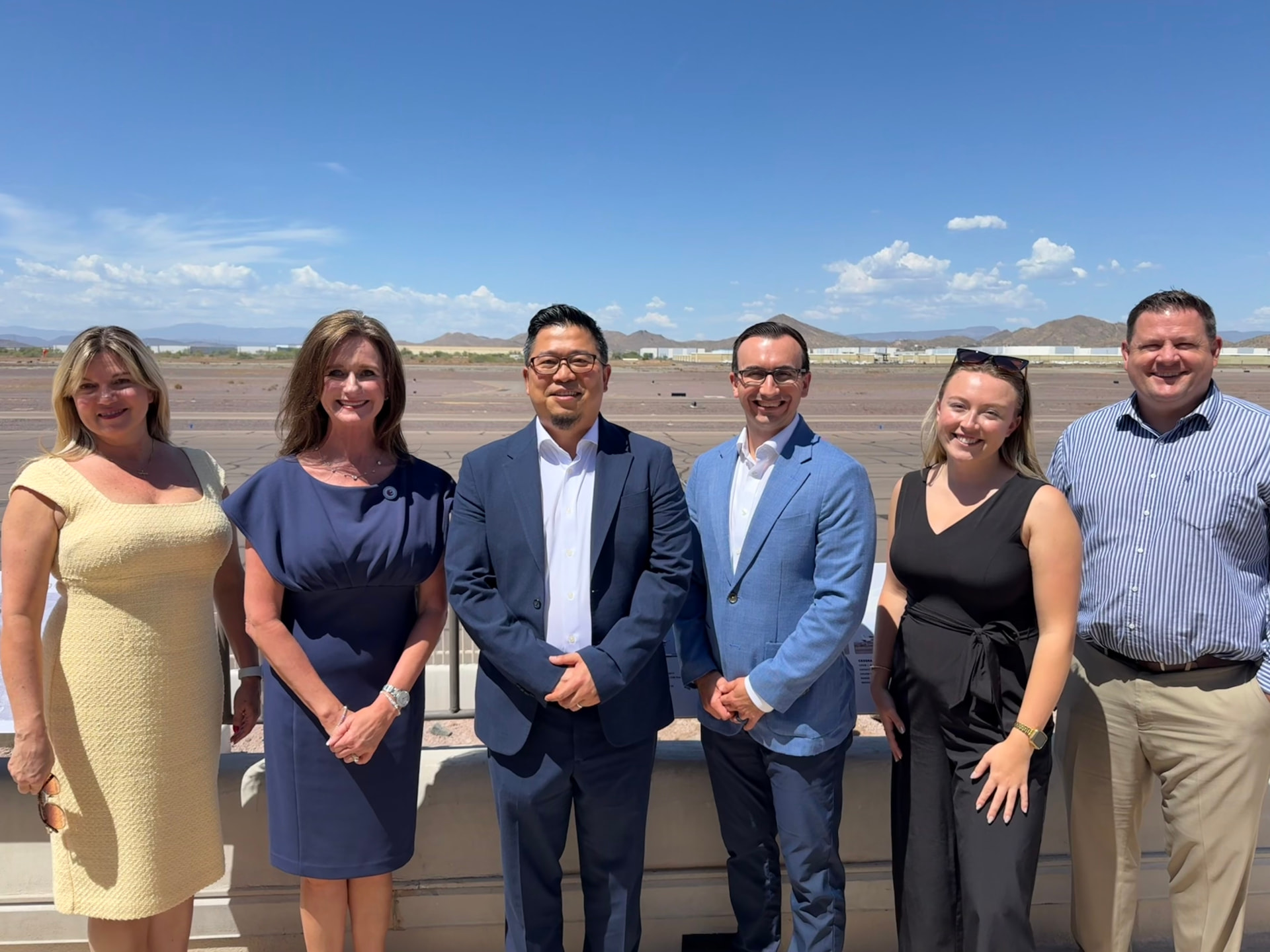 Taicoon Property Partners team and local partners standing on site in north Phoenix with desert mountains in the background