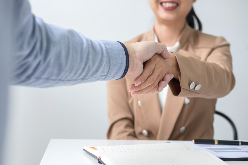 Two businesspeople shaking hands during a meeting to sign agreement and become a business partner, enterprises, companies, confident, success dealing, contract between their firms.